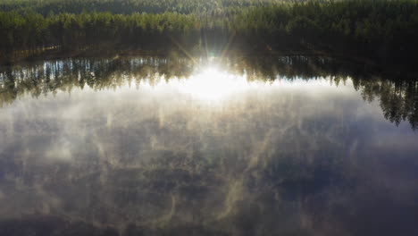 aerial drone footage of pristine misty forest lake in the morning