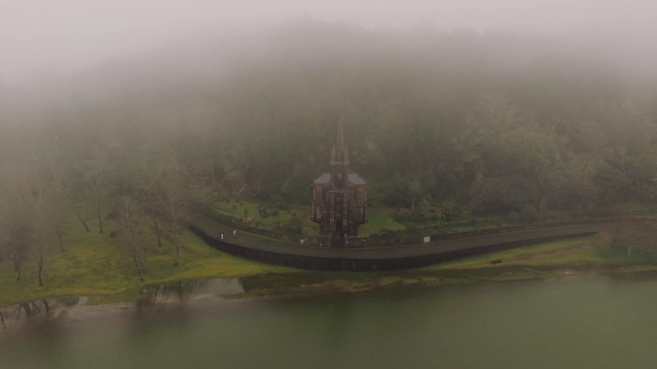 Veduta aerea della cappella di Nossa Senhora das Vitórias al lago di Furnas, nella nebbia, São Miguel, Azzorre.