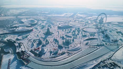 a breathtaking drone shot showcasing the sprawling harbin ice and snow world during the 2025 ice festival. the scene features grand ice sculptures, the snowflake ferris wheel, and a winter wonderland.