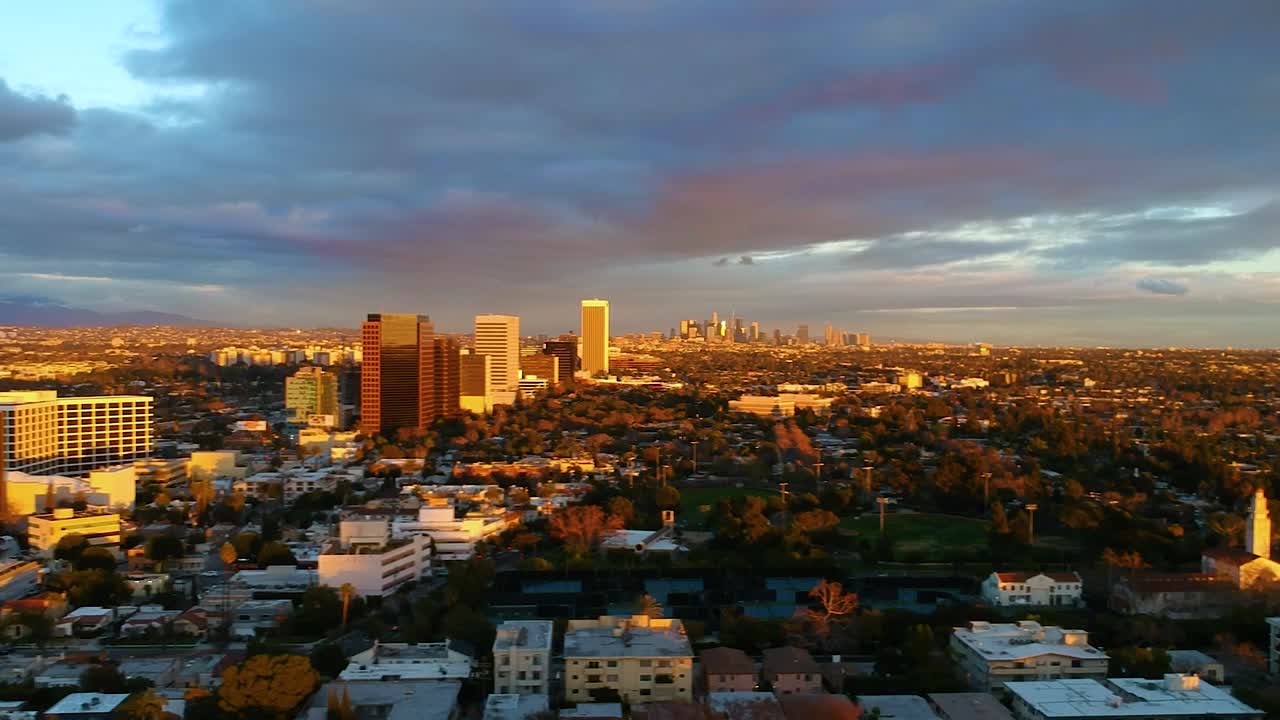 멀리 시내가 보이는 일몰 동안 도시 위를 날아다니는 놀라운 광경