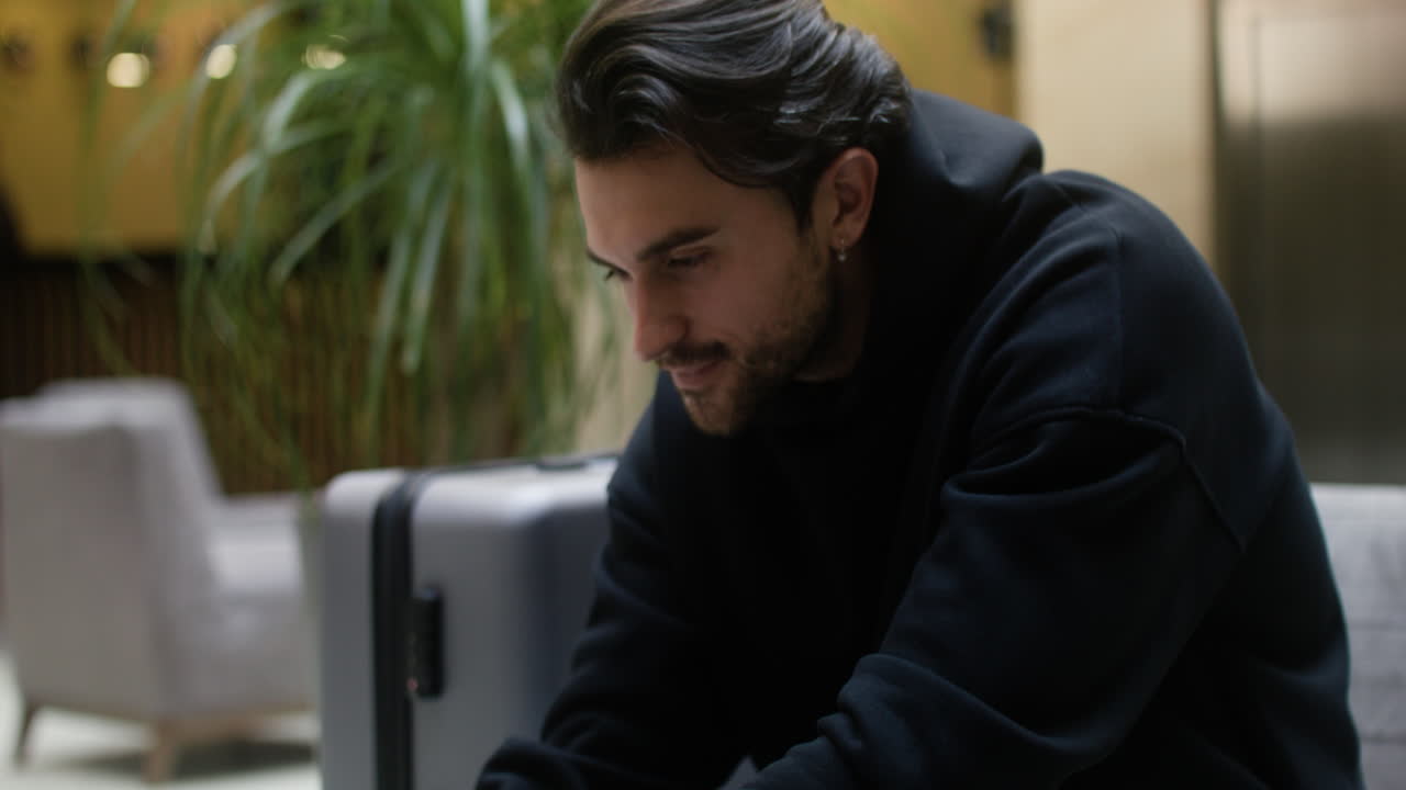 Young man working on laptop at hotel hall
