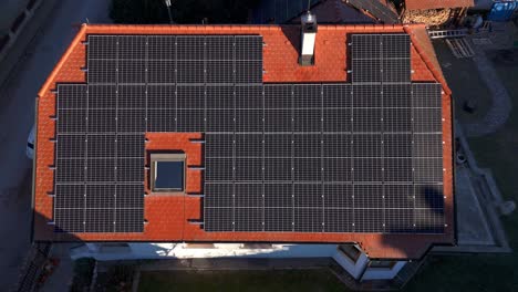 vista de pájaro sobre el sistema fotovoltaico en el techo de baldosas de una casa - toma de un avión no tripulado