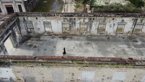 Toma-Aérea-Giratoria-De-Una-Pareja-Caminando-Por-Un-Edificio-Abandonado