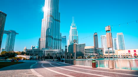 timelapse of burj khalifa on a beautiful day with sun reflection by the fountains.