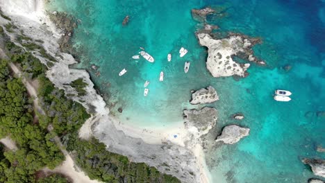 Toma-Aérea-Superior-De-La-Playa-De-La-Isla-Tremiti-Con-Múltiples-Barcos-Navegando-En-El-Mar-Azul-Cristalino