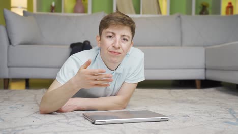 joven frustrado y enojado en casa en la computadora portátil.