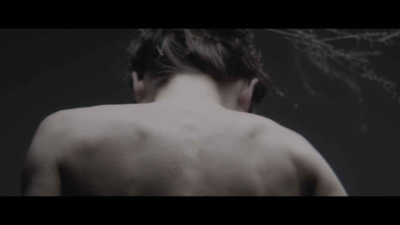 A woman dressed as mother nature moves slowly in a dance-like motion