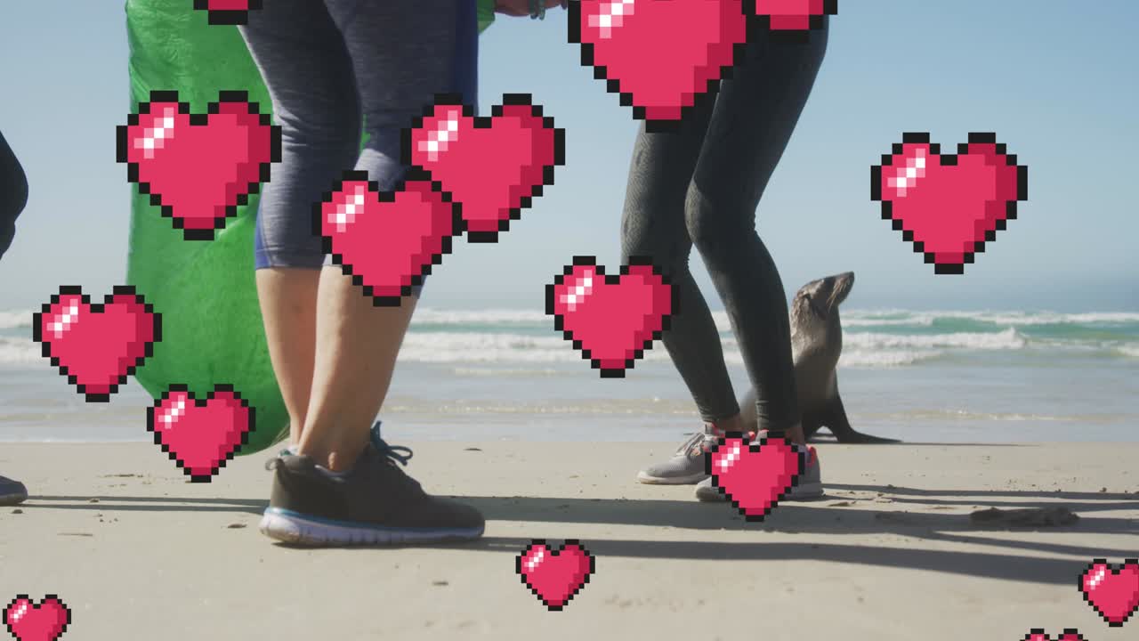 animación de corazones de píxeles rojos flotantes, sobre mujeres recogiendo basura en la playa con foca