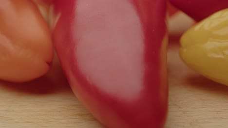 macro inclinación hacia arriba de pimientos de campana coloridos en una superficie de madera