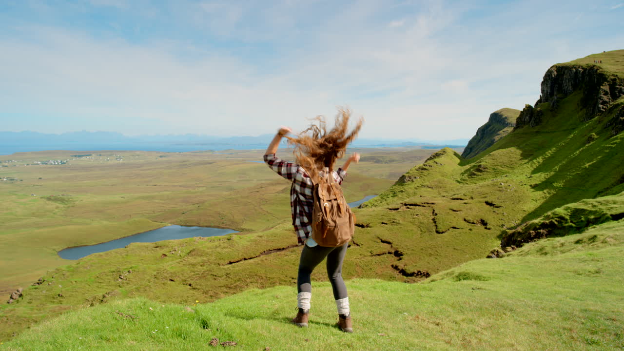 mujer feliz haciendo senderismo en escocia