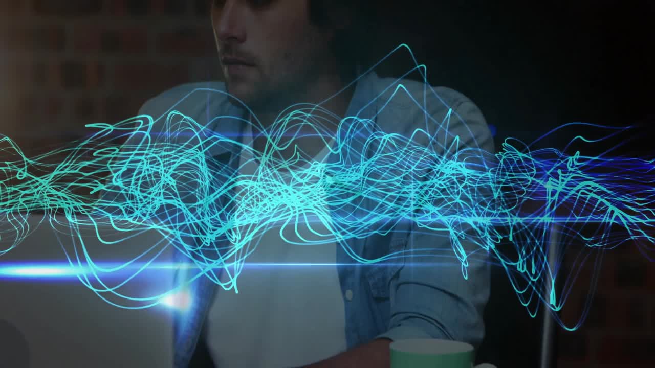 Turquoise waveform appearing and shifting causing man sipping mug and checking audio tech on laptop