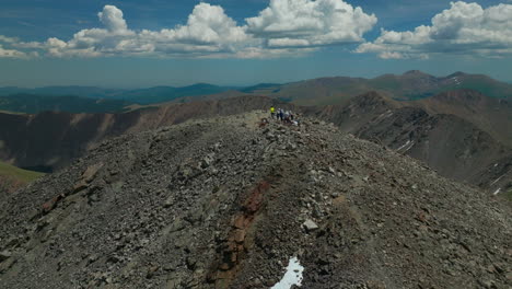 Aerial-cinematic-drone-early-morning-hiking-trail-people-on-Torreys-14er-Peaks-looking-at-Breckenridge-Colorado-stunning-landscape-view-mid-summer-green-beautiful-snow-on-top-upward-movement-slowly