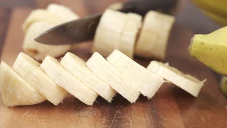 plátanos en rodajas en una tabla de cortar de madera