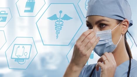 Caucasian-female-surgeon-wearing-face-mask-against-multiple-medical-icons-on-blurred-background