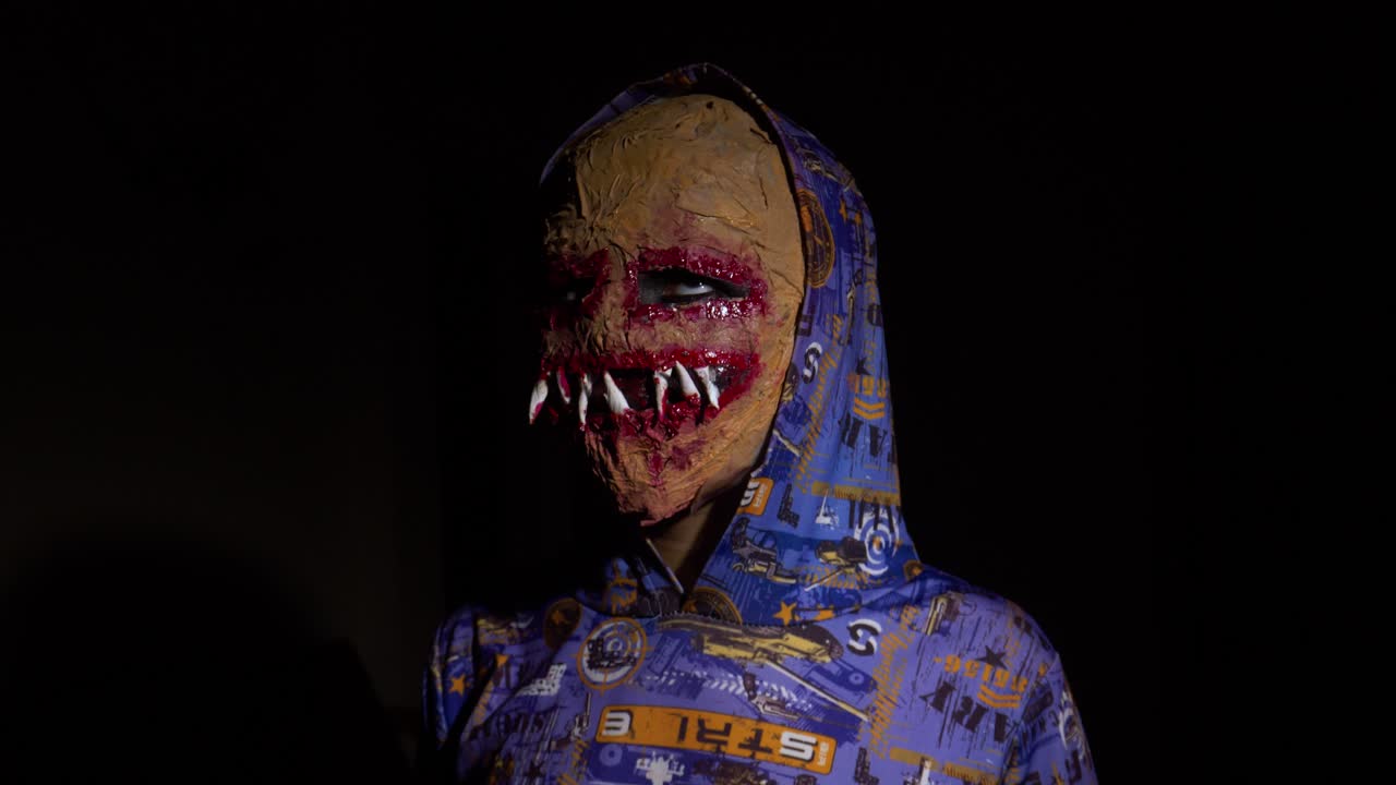 Horror face mask, young boy in dark area
