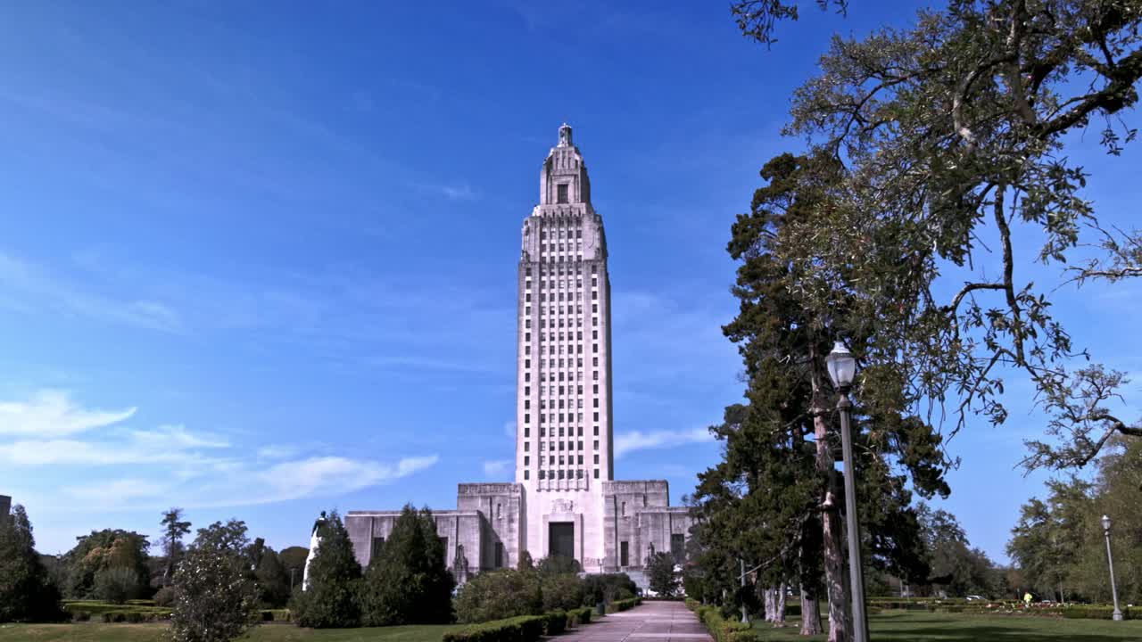 Louisiana state capitol building in Baton Rouge, Louisiana with gimbal video walking forward with trees moving.
