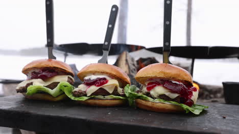 row of prepared reindeer salad cheeseburgers at swedish outdoor snowy barbecue