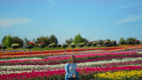 Glückliches-Mädchen,-Das-Draußen-Auf-Floralem-Hintergrund-Läuft.-Junge-Frau-Im-Tulpenfeld.