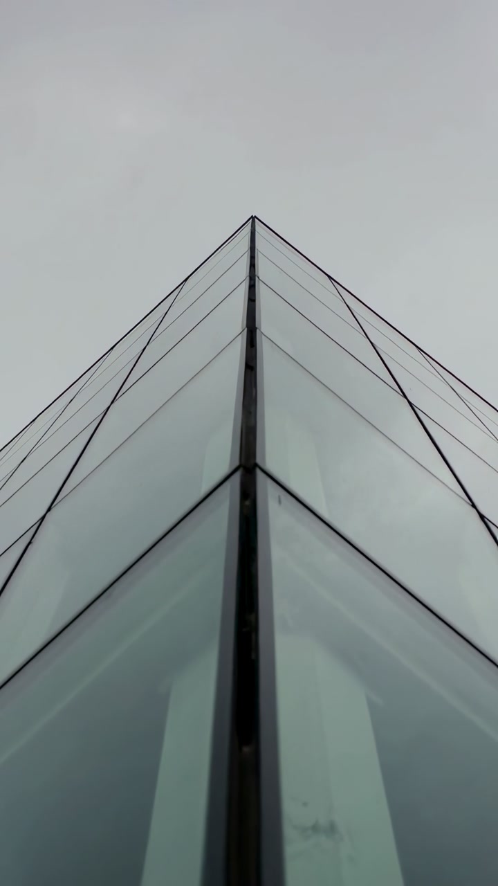 Vertical video: Camera tilting up, corner mullion and glass panels converging into apex for design