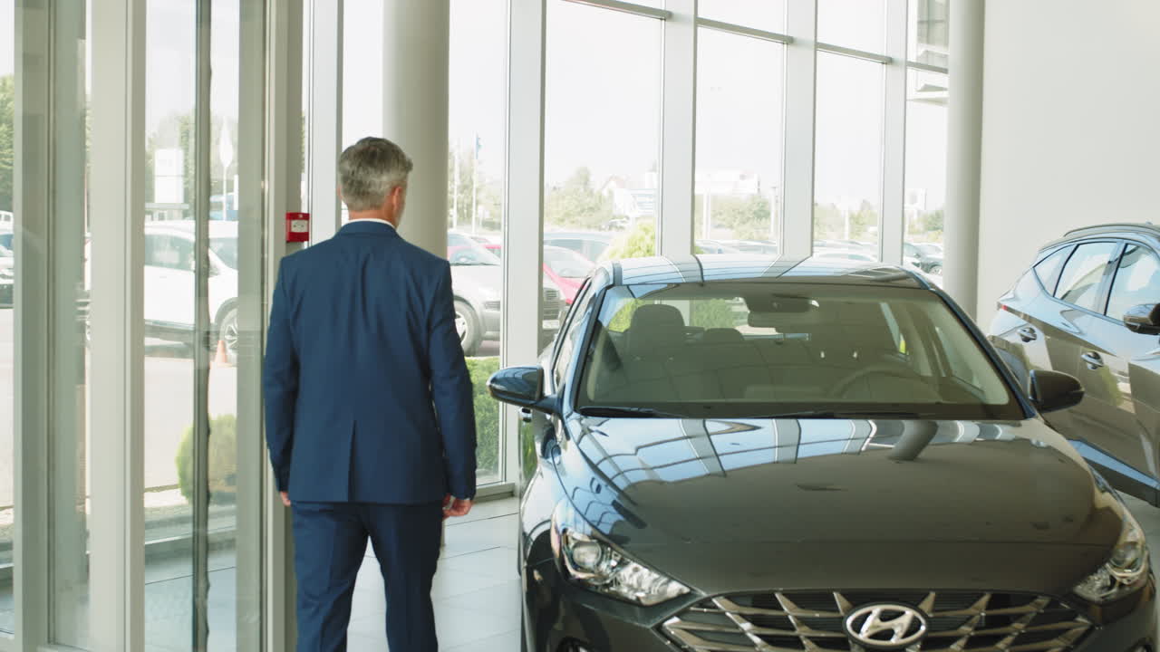 hombre en un traje de negocios en un concesionario de automóviles