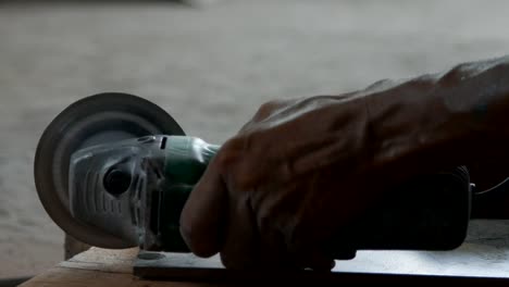 trabajador cortar una baldosa con una amoladora angular en el sitio de construcción