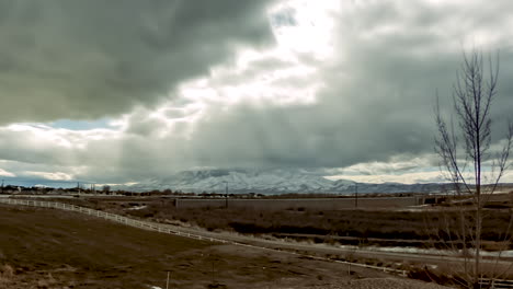 time lapse of a snowy mountain across the valley and dramatic clouds