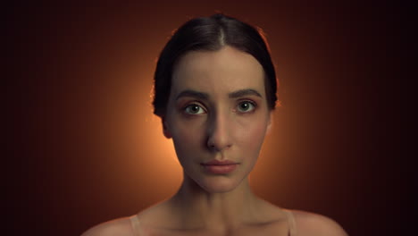 retrato de una mujer graciosa posando con la cámara en el interior. rostro de bailarina de pie en el estudio