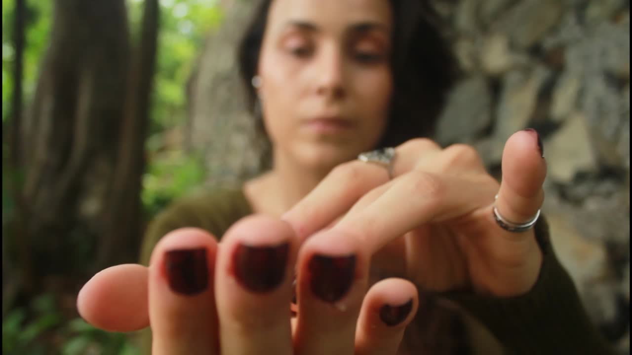 Woman holding a red stone in nature