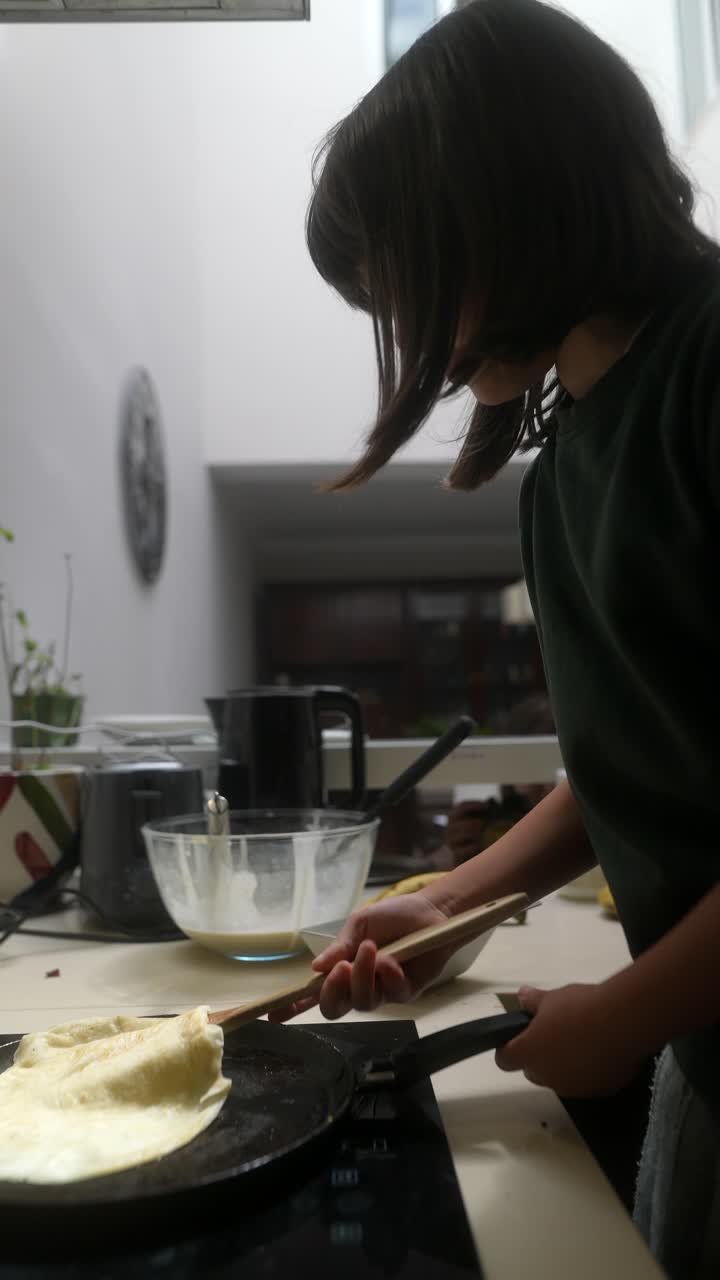 Child Cooking Pancakes in a Kitchen