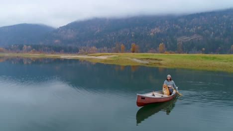 Man-rowing-boat-with-his-dog-on-a-lake-4k