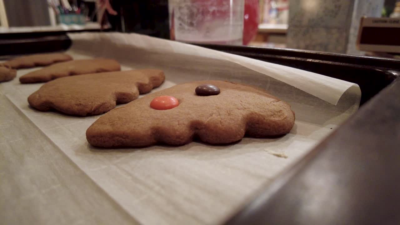 Tight shot of putting candy on gingerbread christmas cookies