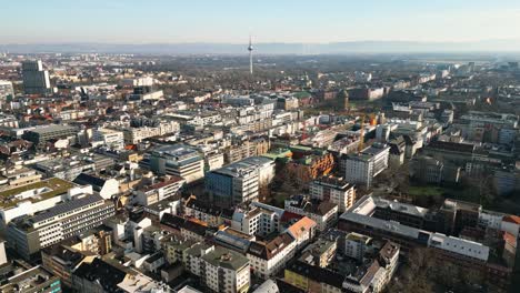 aerial drone footage of downtown mannheim towards the wasserturm and friedrichsplatz on a sunny winter day.