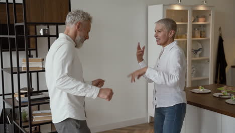 happy senior couple having fun and dancing at home 1