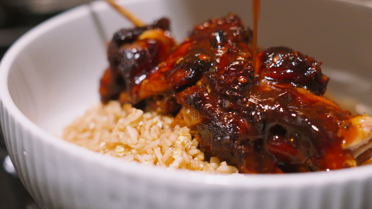 Delicious Japan Teriyaki Miso Chicken King Kebab Resting on Egg Fried Rice with Sauce Being Drizzled Over Dinner Plate Meal Ready to Serve. Japanese Cuisine 4K.