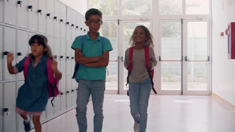 Diverse-group-of-schoolkids-of-different-ages-walking-on-hallway