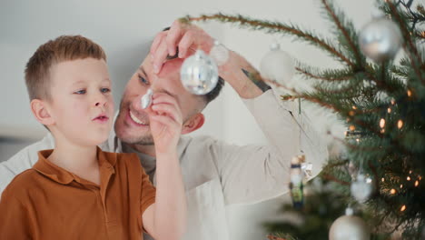 father and son in festive mood by the christmas tree