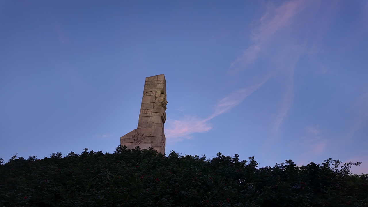 Massive stone monument rising from greenery at blue hour, symbolic and monumental architecture