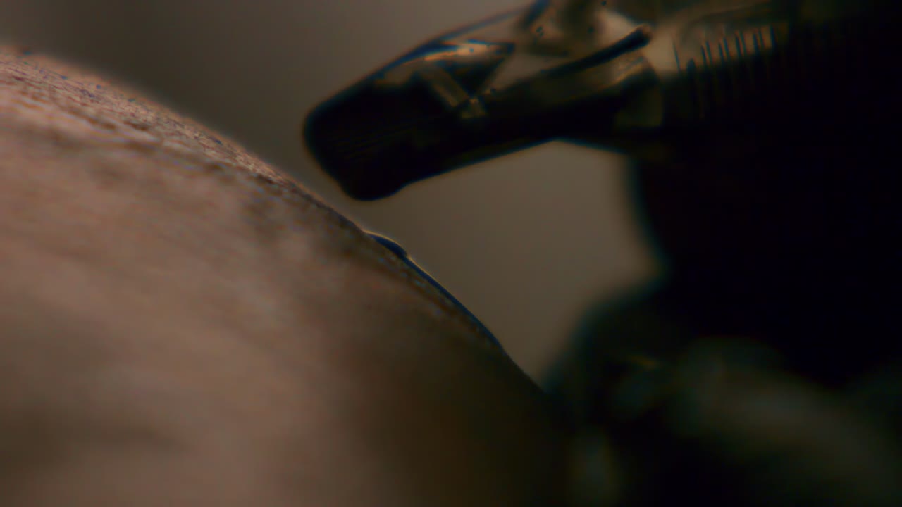 Un tatuatore professionista realizza un tatuaggio sul braccio al rallentatore. Primo piano di un tatuatore che esegue un tatuaggio nello studio.