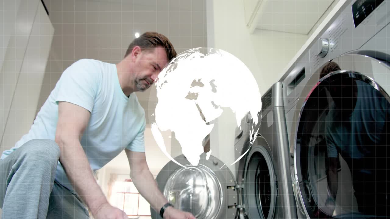 Man entering carrying basket, loading laundry into washer with HUD globe overlaying, preparing wash
