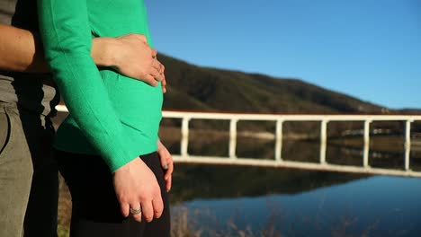 male hand gently caresses the pregnant belly of the girl, close up shot