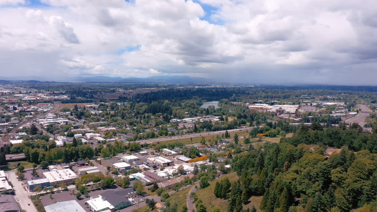 cielo nublado de verano sobre el horizonte de la ciudad con frondosos árboles en eugene, oregon - antena
