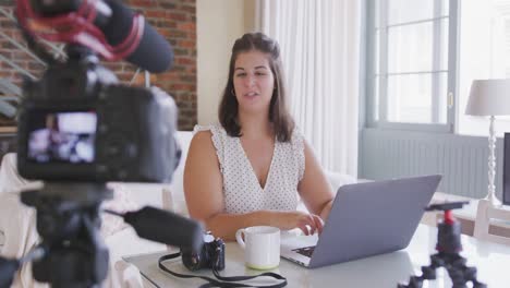 caucasian vlogger woman doing a video at home