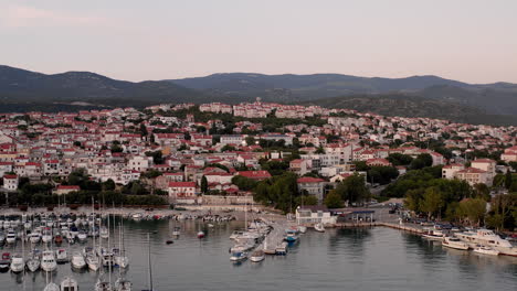 Toma-Aérea-Que-Revela-La-Famosa-Costa-De-Novi-Vinodolski,-Croacia,-Hermosos-Balcanes,-Arquitectura-Mediterránea,-Pueblo-Viejo,-Puerto-Lleno-De-Barcos,-Puesta-De-Sol,-Veleros,-Lanchas-Rápidas,-Lanchas-Motoras,-Viaje