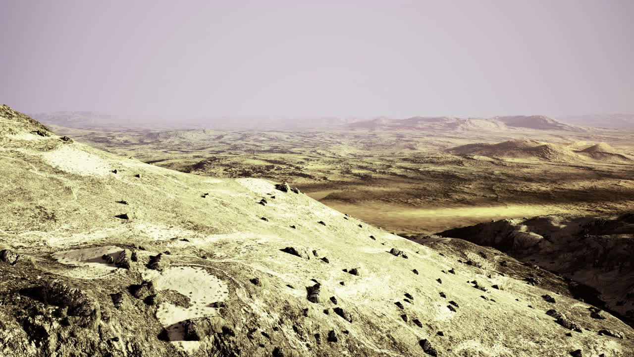 Widespread rocky landscape with distant valleys under hazy sky