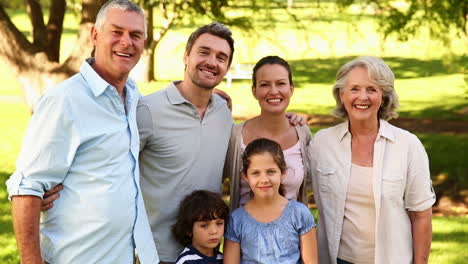 familia extendida feliz sonriendo a la cámara afuera