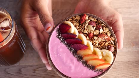 pink coconut bowl with yogurt, granola, and fruits