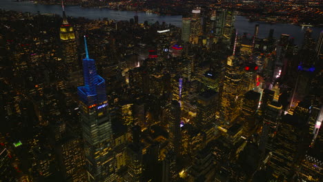 Vista-Aérea-De-La-Ciudad-De-Noche.-Varios-Edificios-Altos-Iluminados-En-El-Centro-De-La-Ciudad.-Manhattan,-Ciudad-De-Nueva-York,-Estados-Unidos