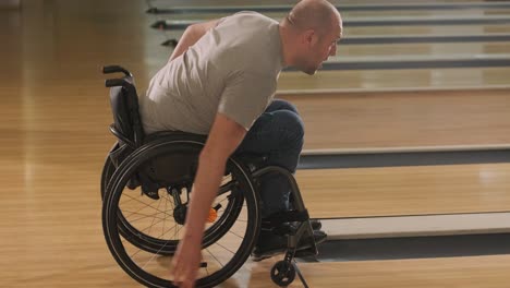 two young disabled men in wheelchairs playing bowling in the club