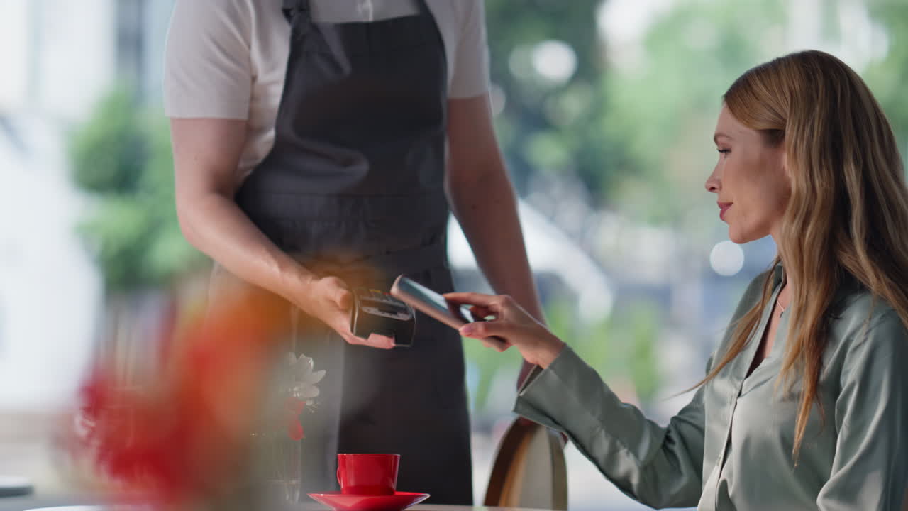 Woman cafe client paying for coffee sitting modern interior closeup. Man waiter