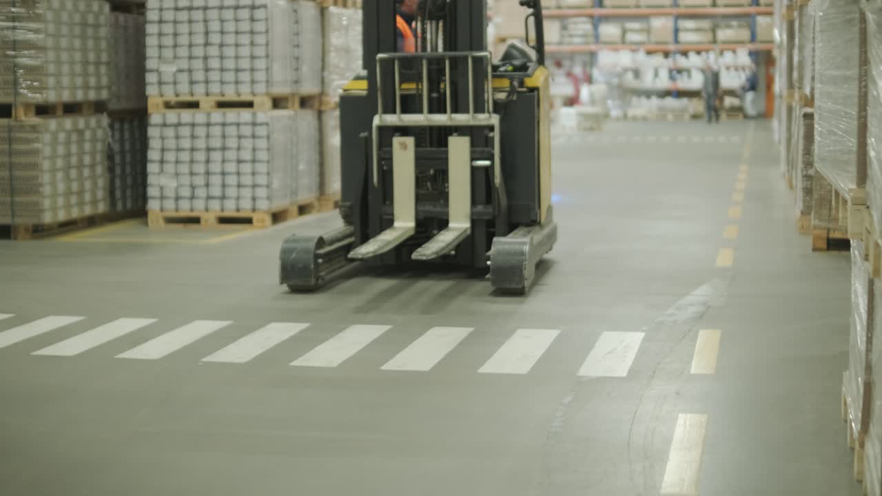 Forklift Moving Through a Large Warehouse Aisle